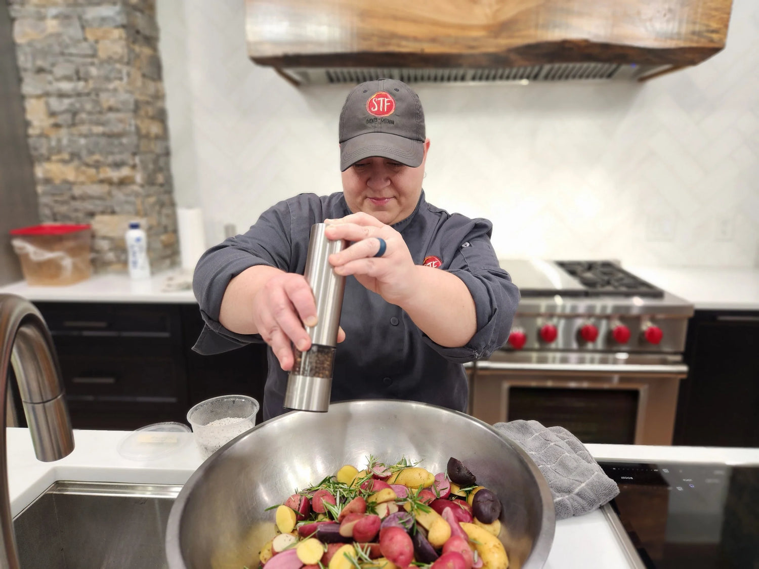 Person seasoning vegetables in a kitchen