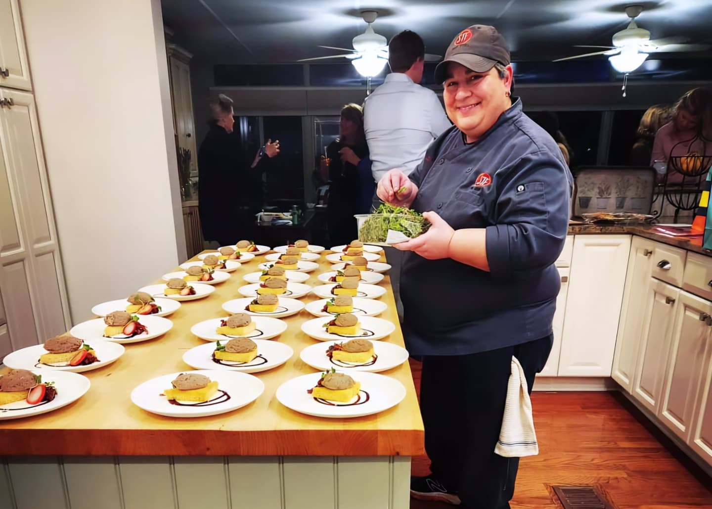 Person in a kitchen preparing food with a large array of dishes on a counter.